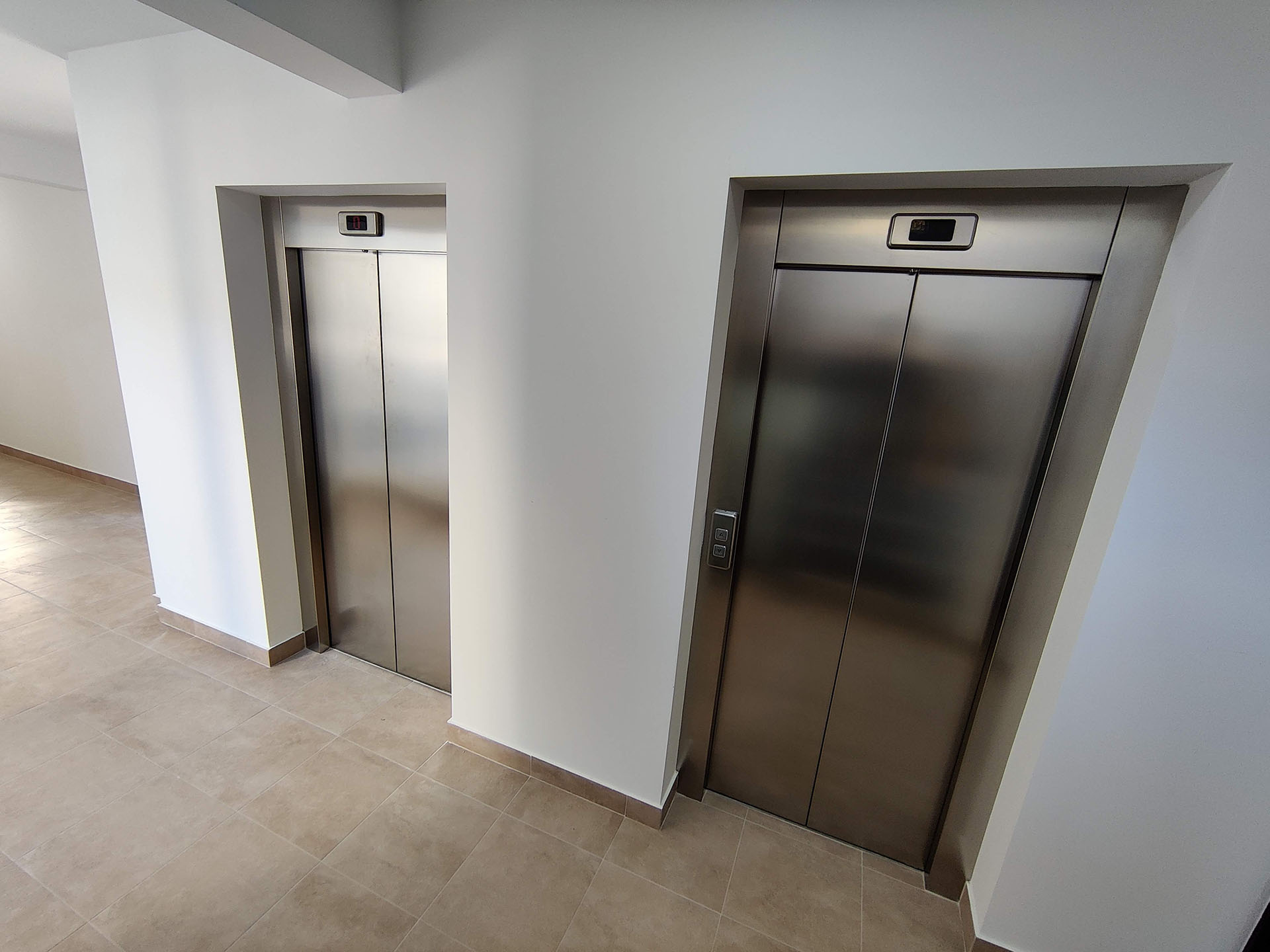 Modern elevator lobby with light-toned finishes in a residential complex in Bečići, Montenegro.