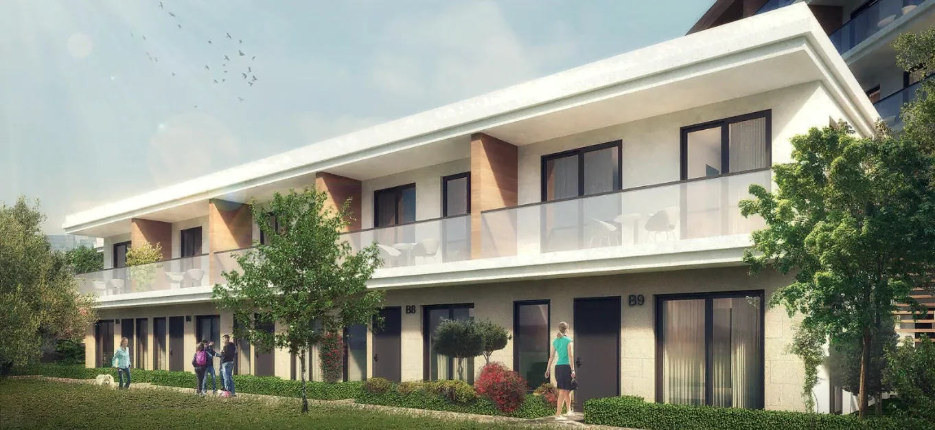 Außenansicht eines modernen zweistöckigen Apartmentgebäudes mit Balkonen, Glasgeländern und Personen.
