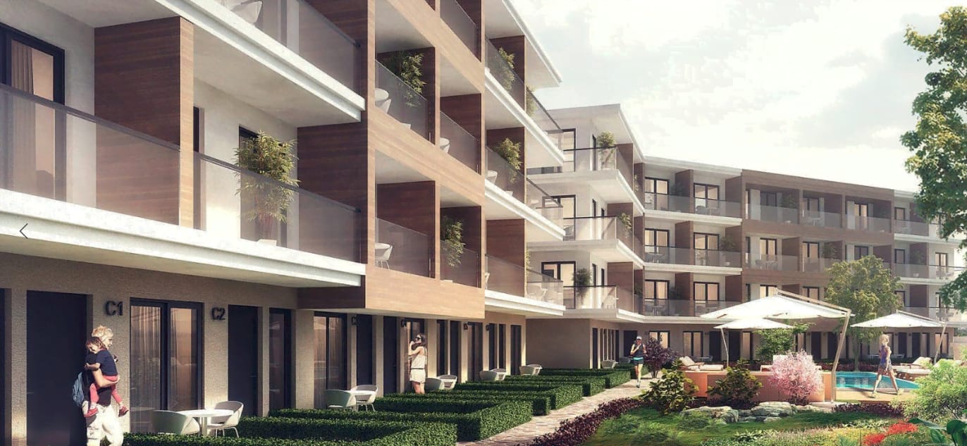 Modern residential complex in Kavac, Montenegro: facade with terraces, landscaping, and an outdoor swimming pool.