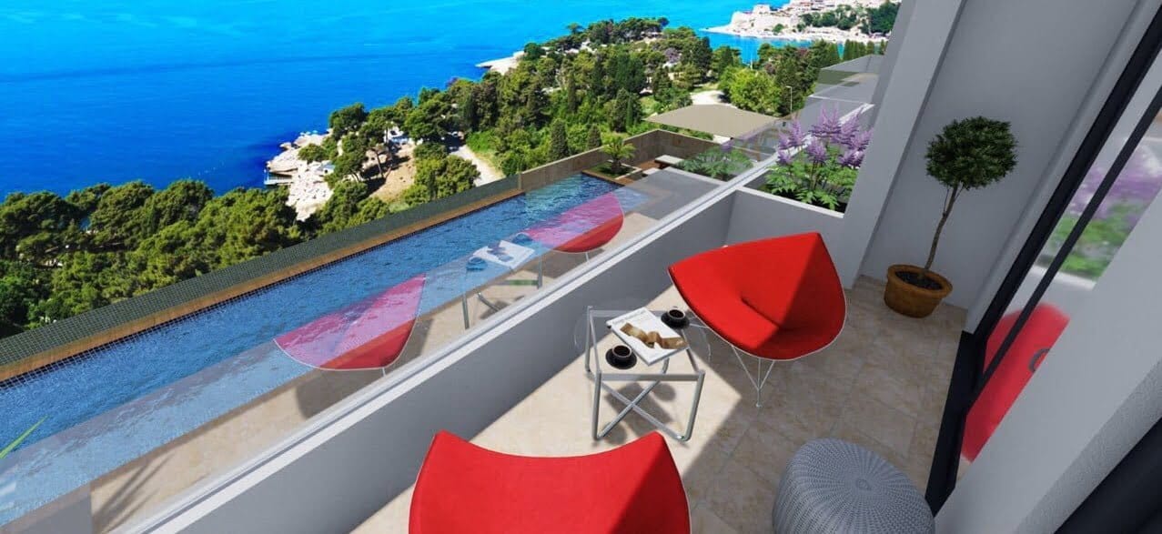 Balcony with red chairs and a view of the sea and pool in a residential complex in Ulcinj, Montenegro.