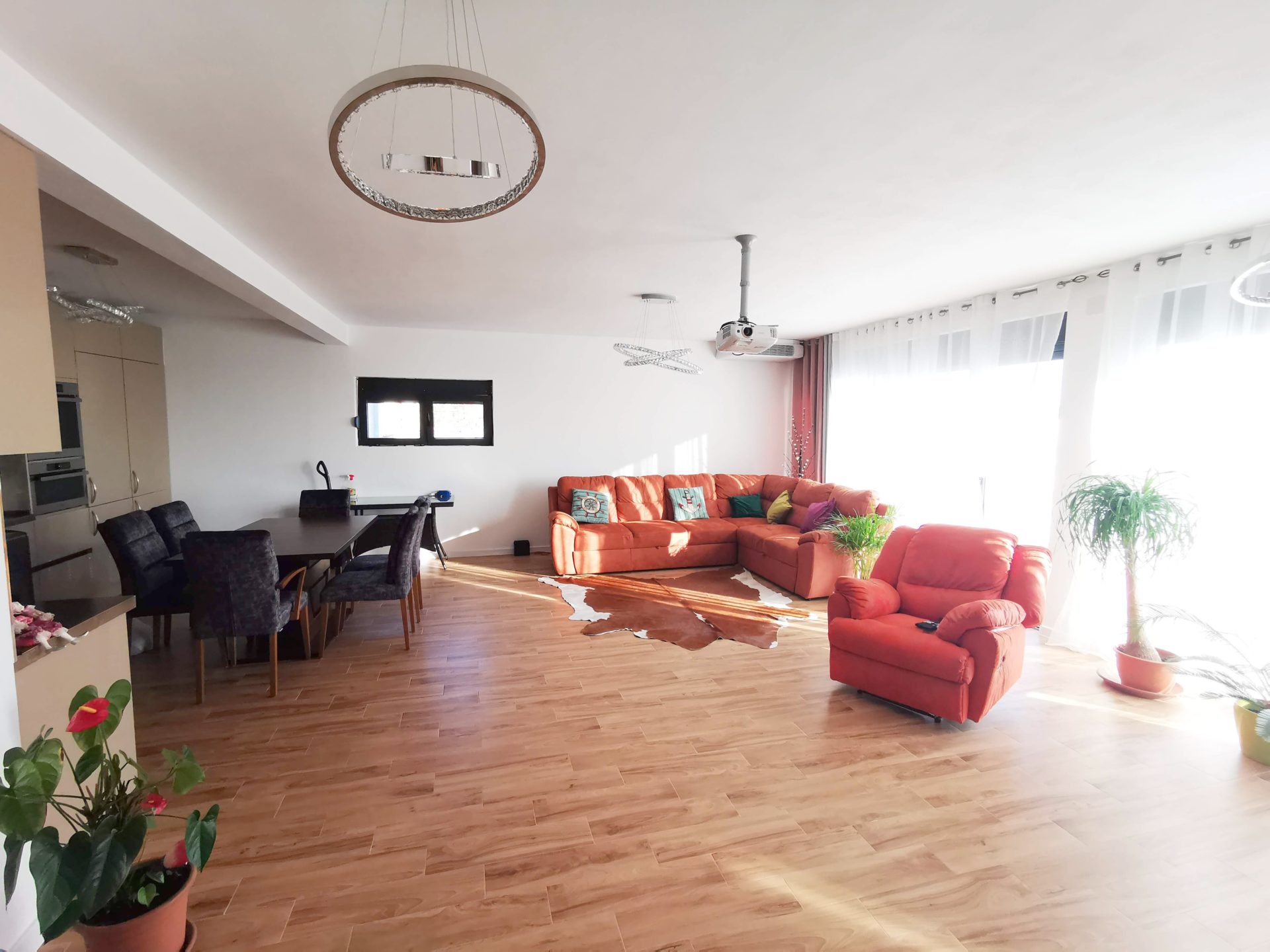 Przestronny salon z pomarańczową sofą i jadalnią w willi w mieście Bar, Czarnogóra.