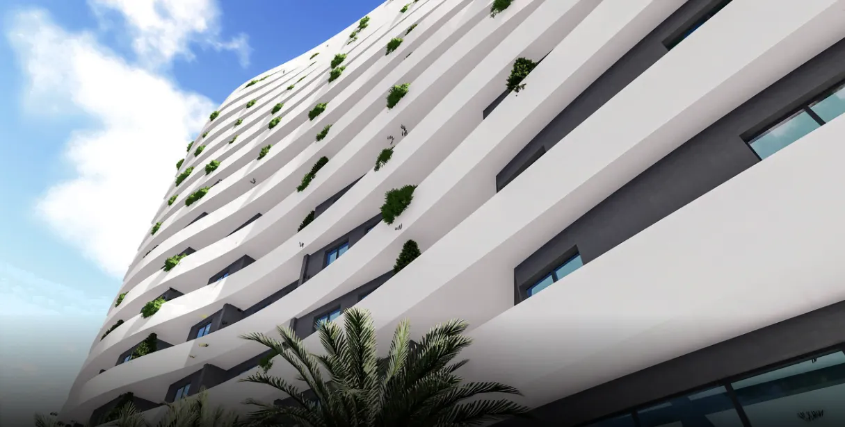 Modern residential complex with curved white facades and landscaping in Rafailovići, Montenegro. View of the building from below.