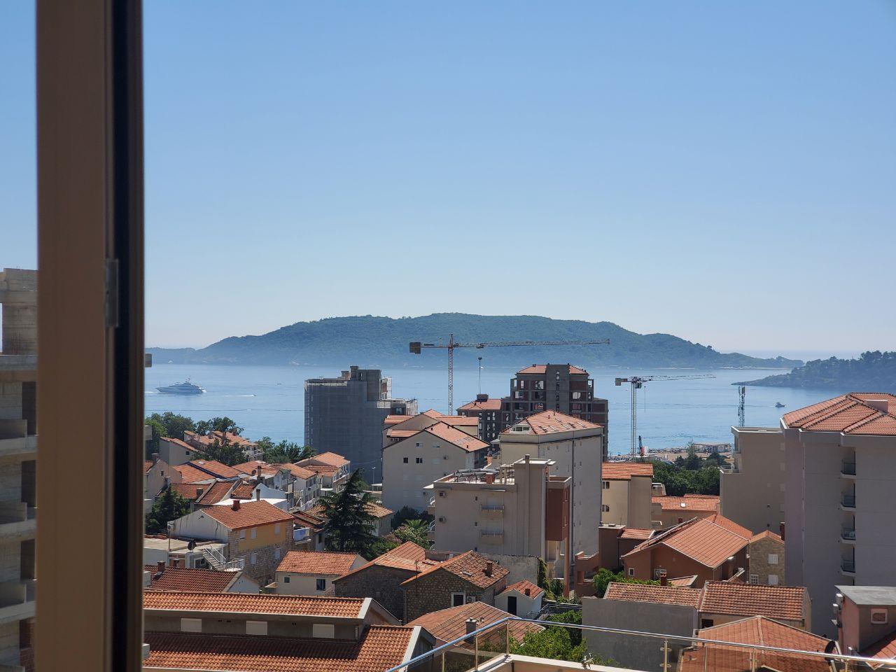 Pogled na more, planine i grad sa balkona.