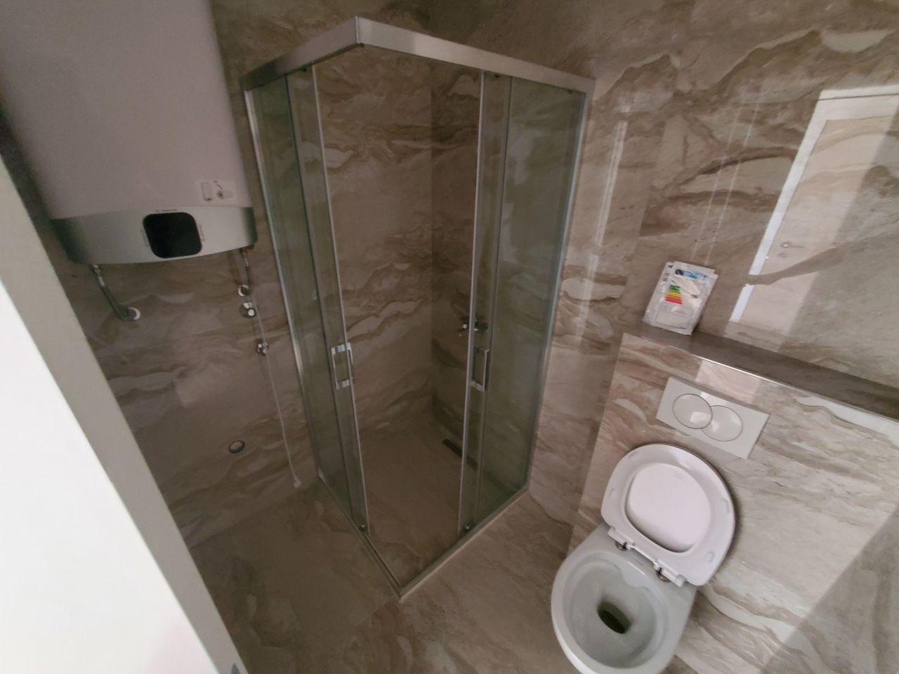 Moderno popločano kupatilo sa tuš kabinom i wc šoljom