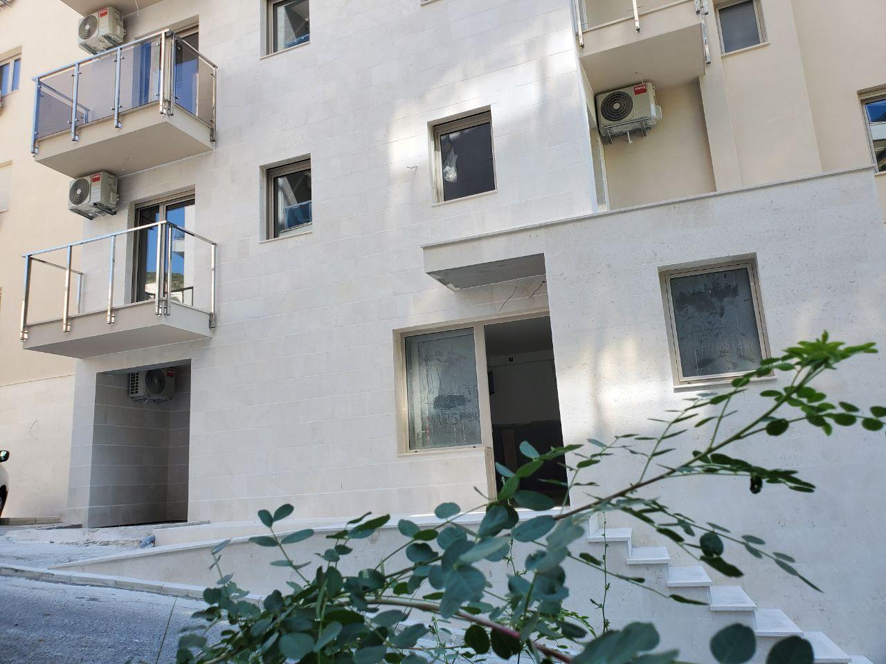 Fasada svetle stambene zgrade sa balkonima i prozorima