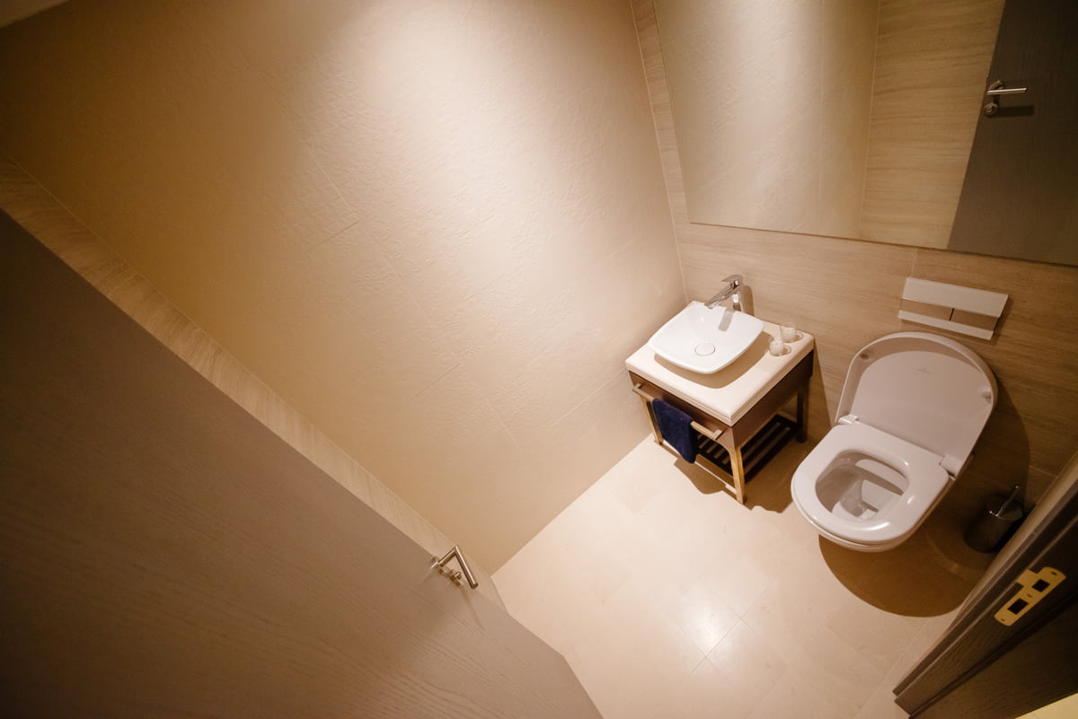 Karadağ, Kumbor’daki bir dairede beyaz sıhhi tesisatlı modern banyo: şık kaplama ve ayna.