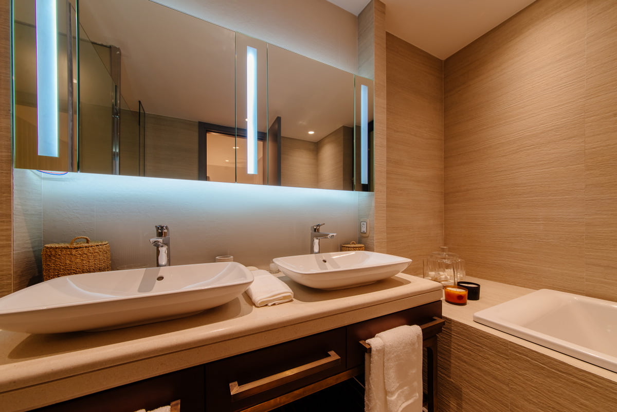 Kumbor, Karadağ’daki lüks bir dairede iki lavabolu modern banyo: şık kaplama ve aydınlatma.