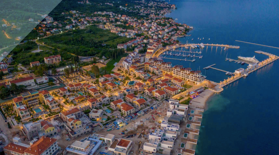 Karadağ, Kumbor’daki Porto Novi tatil kompleksinin marinaya ve akşam aydınlatmasına sahip havadan panoramik görünümü.