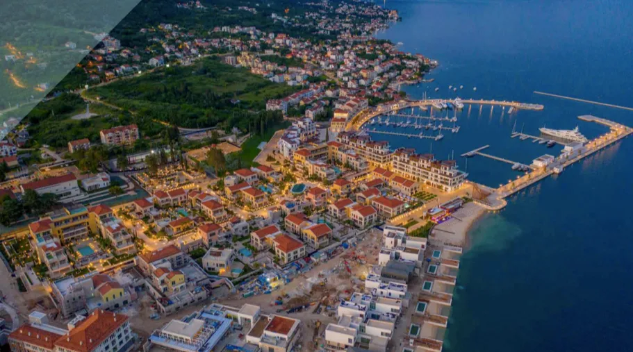 Panoramablick aus der Luft auf den Ferienkomplex Porto Novi in Kumbor, Montenegro, mit Marina und abendlicher Beleuchtung.