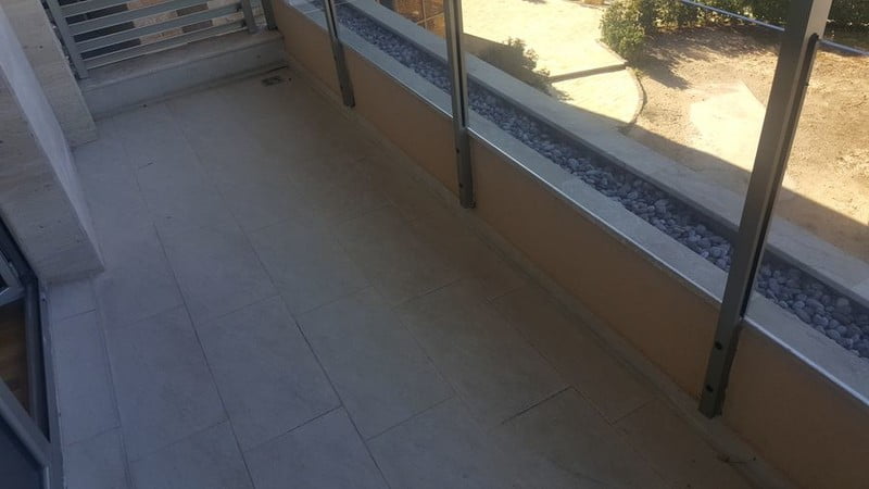 Taş kaplamalı ve cam korkuluklu geniş balkon, modern bir dairede, Bečići, Karadağ.