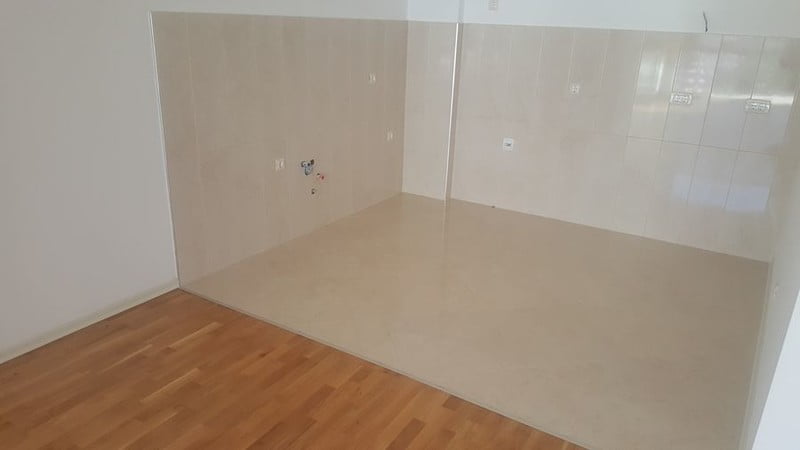 Bečiçi, Karadağ’daki dairede mutfak alanı: zeminde ve duvarlarda açık renkli fayanslar, iletişim bağlantıları için hazırlanmış çıkışlar.