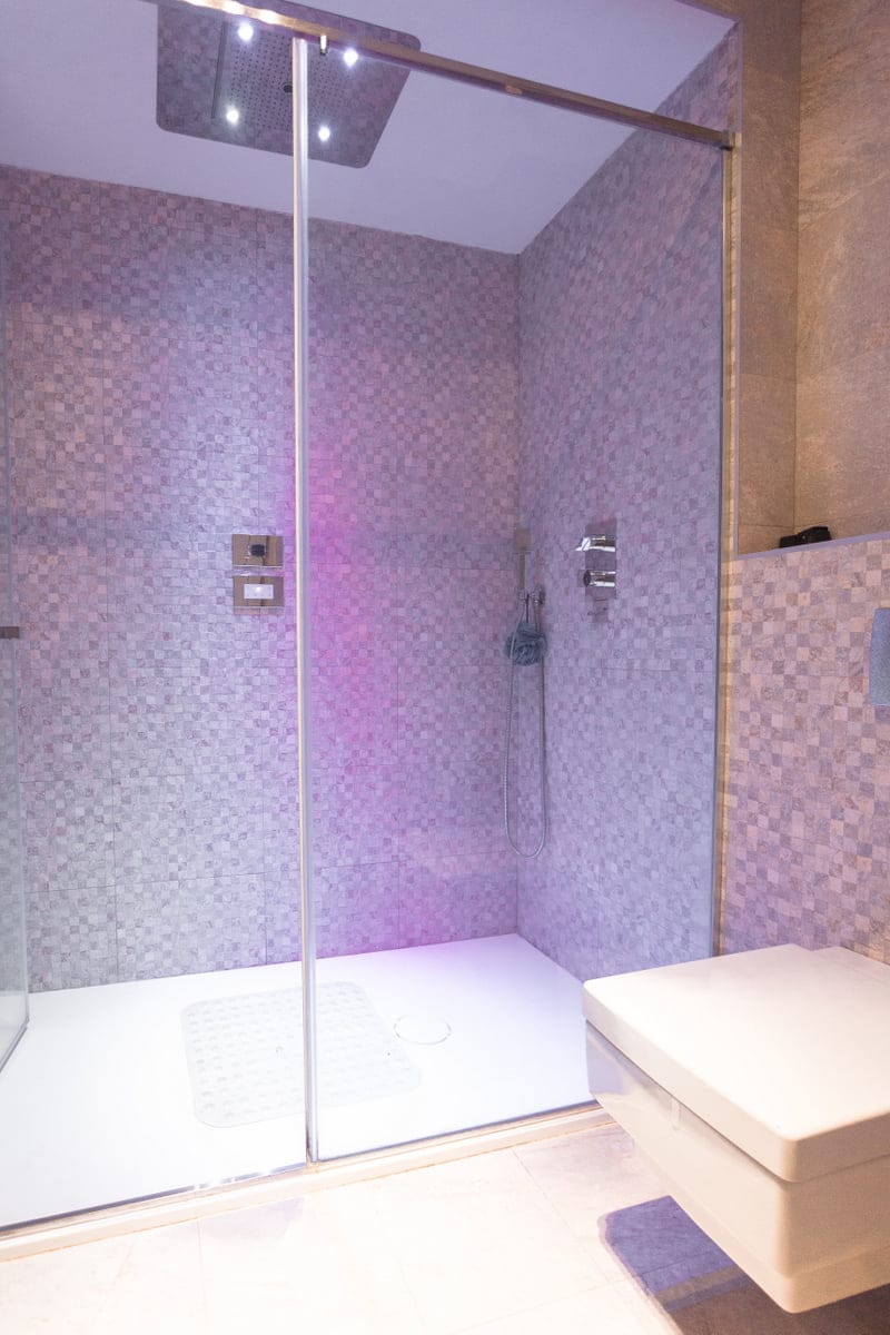 Cabine de douche moderne avec douche tropicale et éclairage dans la salle de bain de l’appartement à Ljuta, Monténégro.