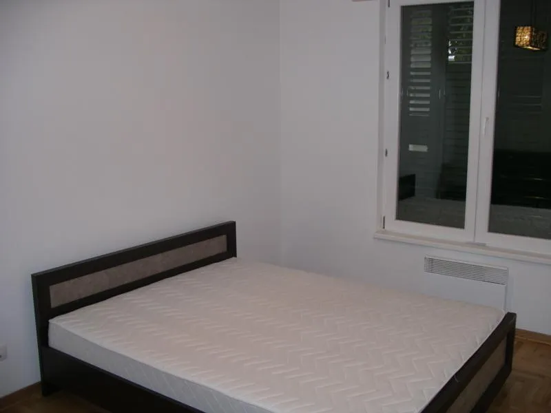Schlafzimmer mit Doppelbett und Panoramafenster in einer Wohnung, Herceg Novi, Montenegro. Helle Ausstattung und Parkett.