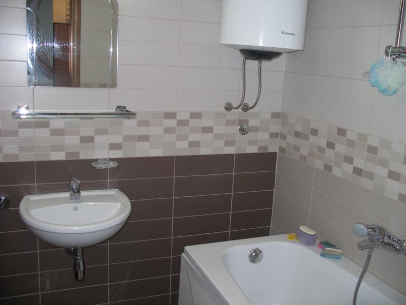 Hersek Novi, Karadağ’daki dairede modern fayanslı banyo: küvet, lavabo ve бойлер установлен.