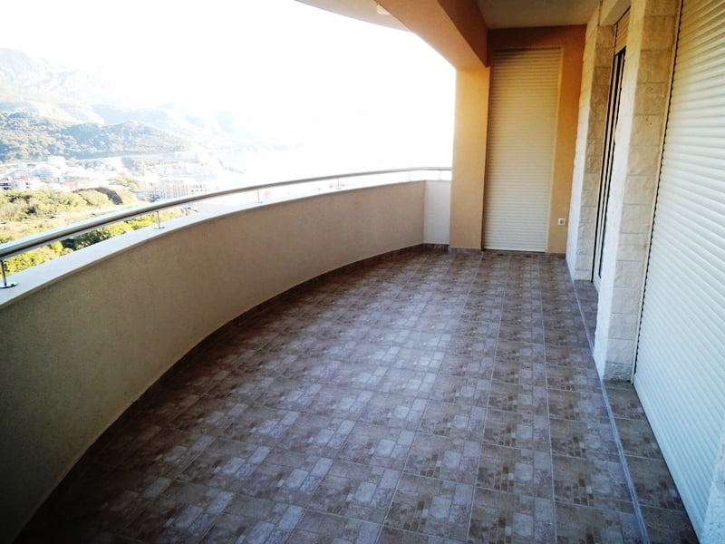 Geräumiger Balkon mit Blick auf das Meer und die Berge in einer Wohnung, Stadt Bečići, Montenegro: Fliesenboden und Schutzrollläden.