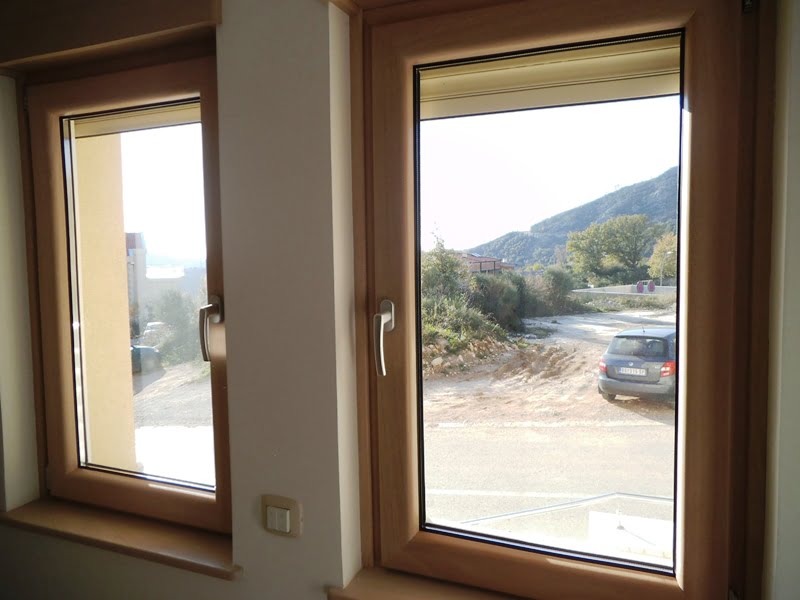 Blick aus dem Wohnzimmerfenster auf die Berge und die Straße in einer Wohnung, Bečići, Montenegro: moderne Holzfenster mit Doppelverglasung.