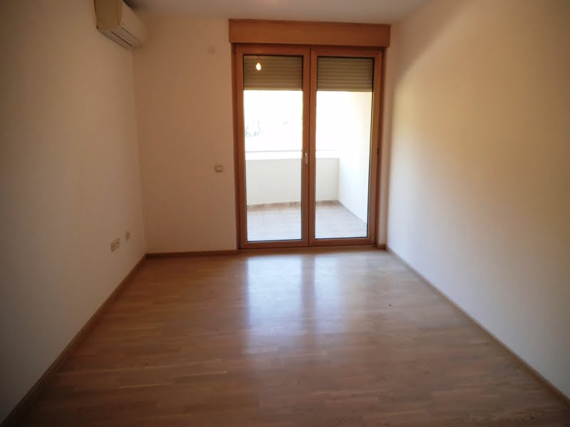 Helles Wohnzimmer mit Parkett und Zugang zum Balkon in einer Wohnung, Bečići, Montenegro.