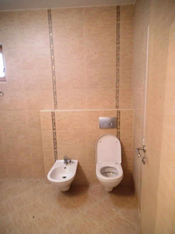 Badezimmer mit Hänge-WC und Bidet in einer Wohnung, Stadt Bečići, Montenegro. Helle Fliesen, modernes Interieur.