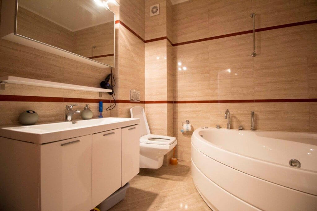 Köşe küvetli ve beyaz mobilyalı modern banyo, dairede, Stoliv, Kotor Körfezi, Karadağ.