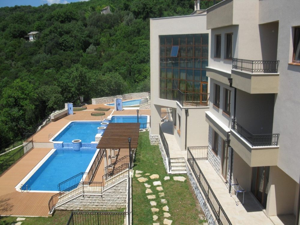 Wohnanlage in Igalo, Montenegro: moderne Apartments mit kaskadenförmigen Pools und Blick auf ein grünes Waldgebiet.