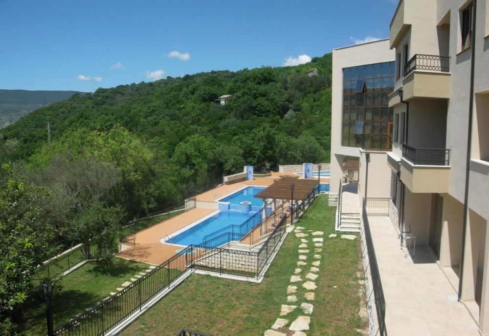 Wohnanlage in Igalo, Montenegro: modernes Gebäude mit Pool, grüner Anlage und Panoramablick auf die Berge.