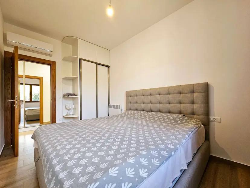 Gemütliches Schlafzimmer mit Doppelbett und Einbauschrank in einer Wohnung zum Verkauf, Budva, Montenegro.