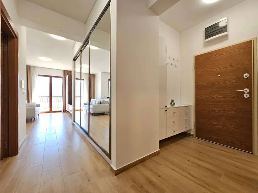 Flur mit Spiegelschiebetürschrank und Eingangstür in einer modernen Wohnung in Budva, Montenegro.