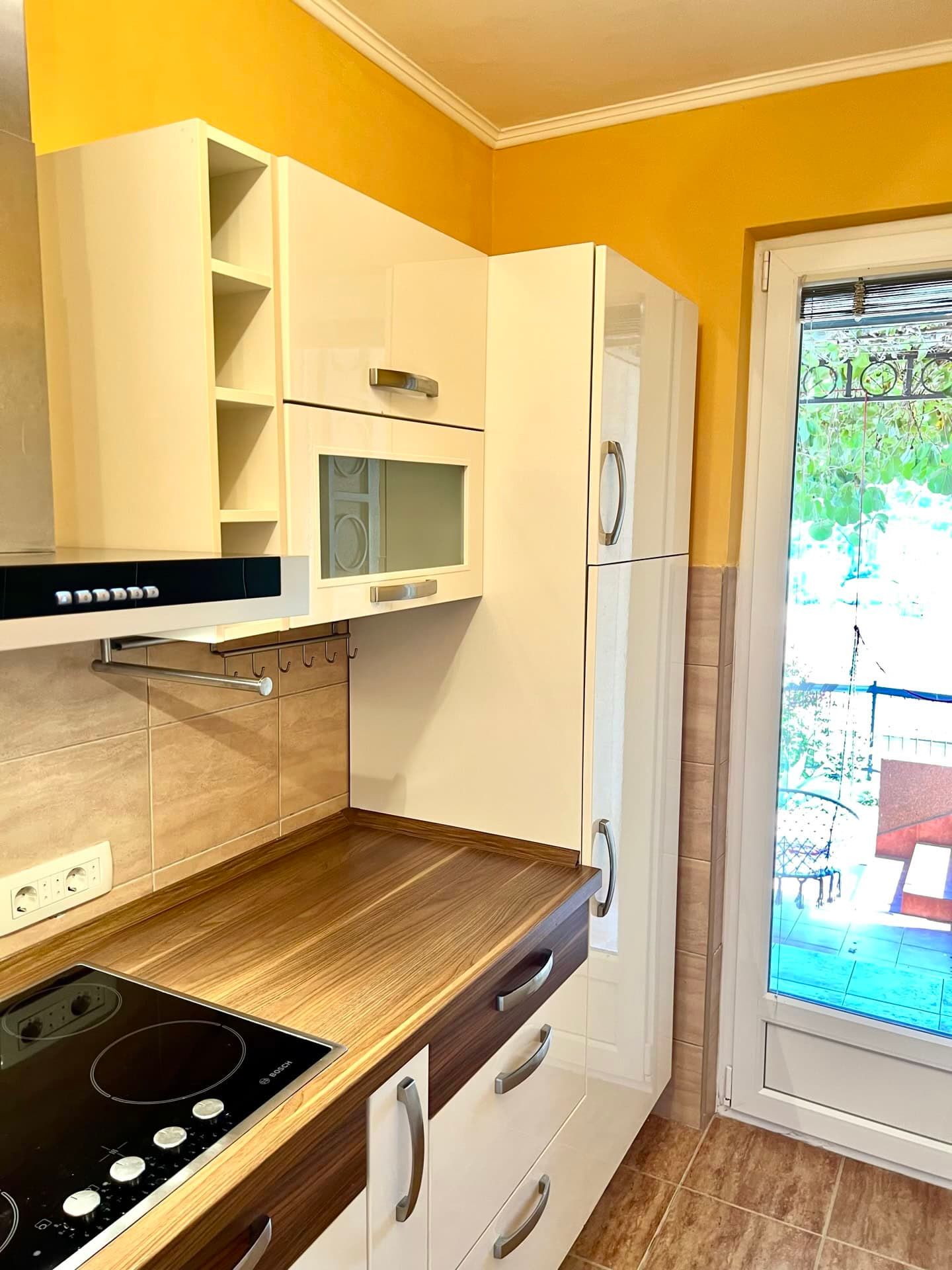 Cuisine moderne avec mobilier blanc et accès à la terrasse dans un appartement, Petrovac, Monténégro.
