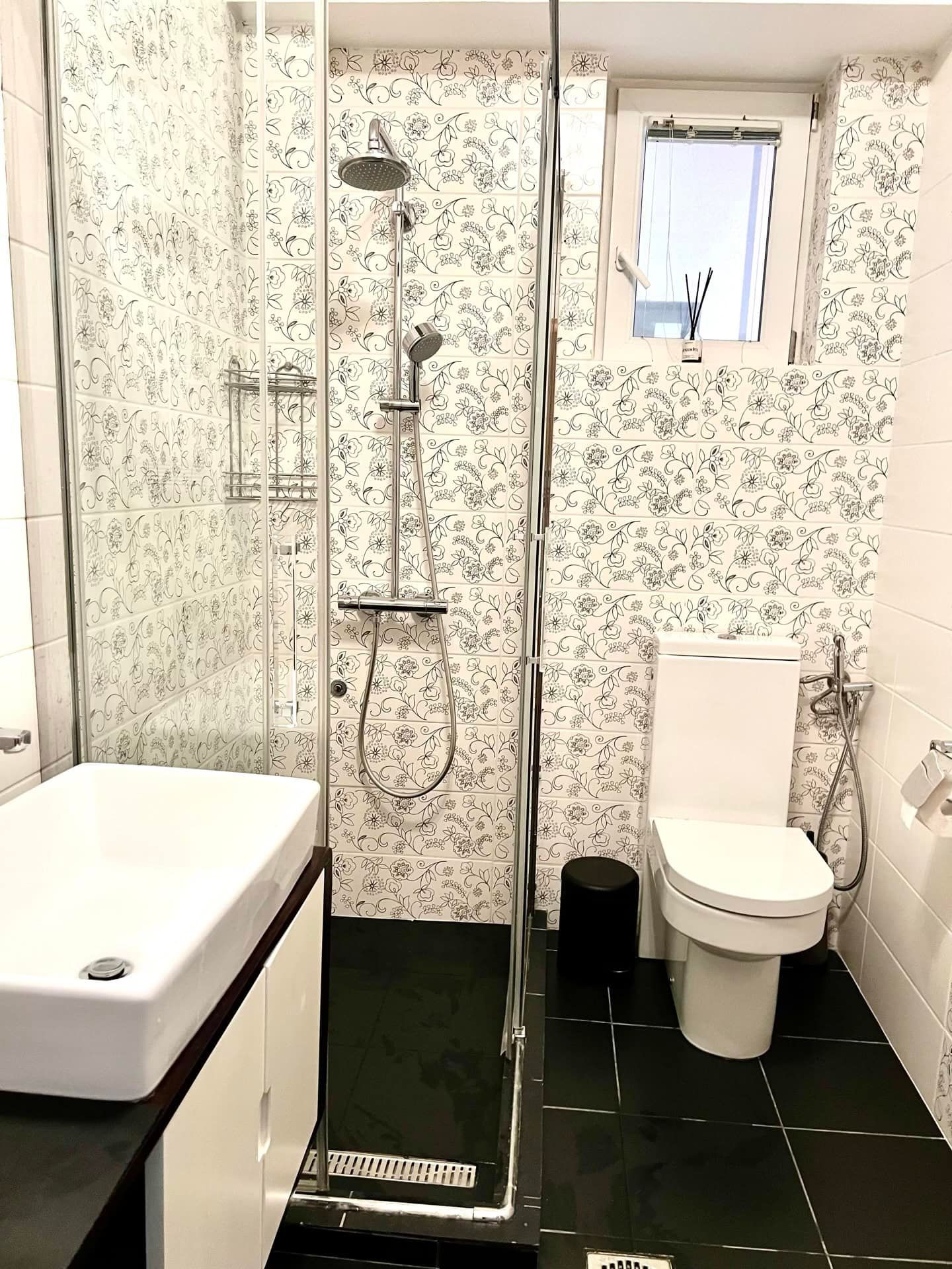 Salle de bains moderne avec cabine de douche dans un appartement à Petrovac, Monténégro : carrelage et sanitaires élégants.