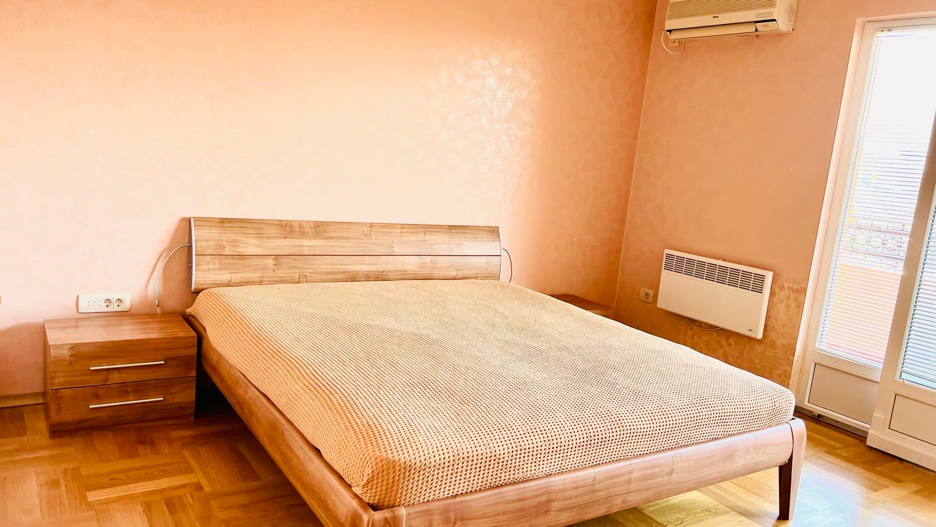 Chambre avec lit double et parquet dans un appartement à Petrovac, Monténégro. Intérieur cosy avec climatisation.