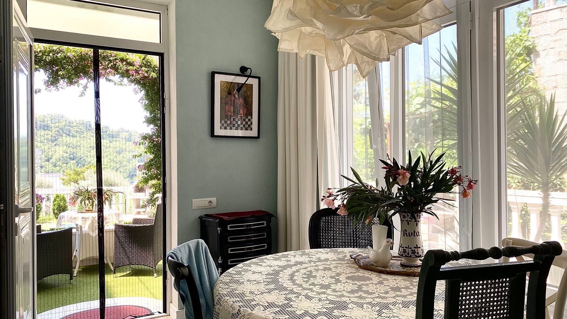 Cozy living room with dining area and access to the terrace in an apartment in Petrovac, Montenegro. Bright interior with decor.