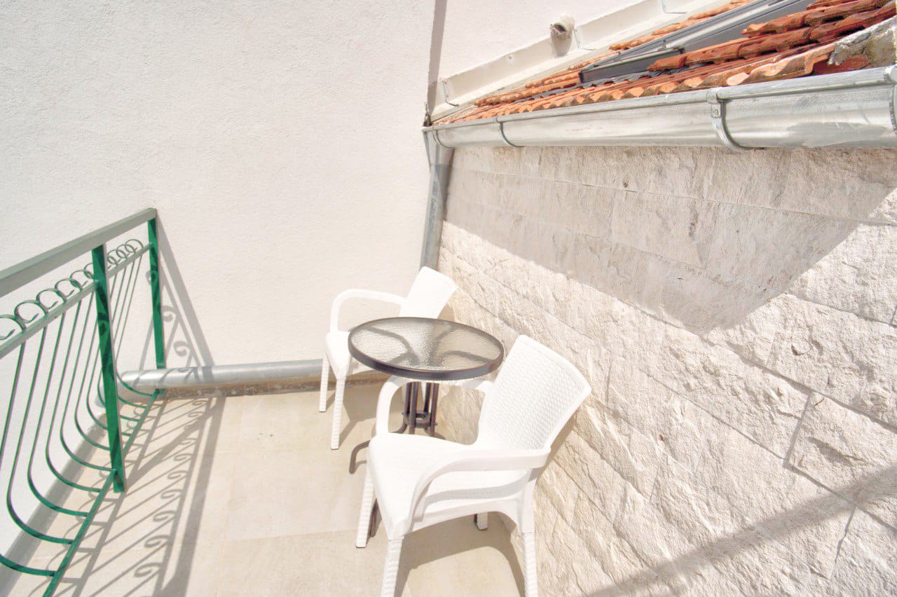 Cozy balcony with plastic furniture and stone finishes in a duplex, Baošići, Montenegro.