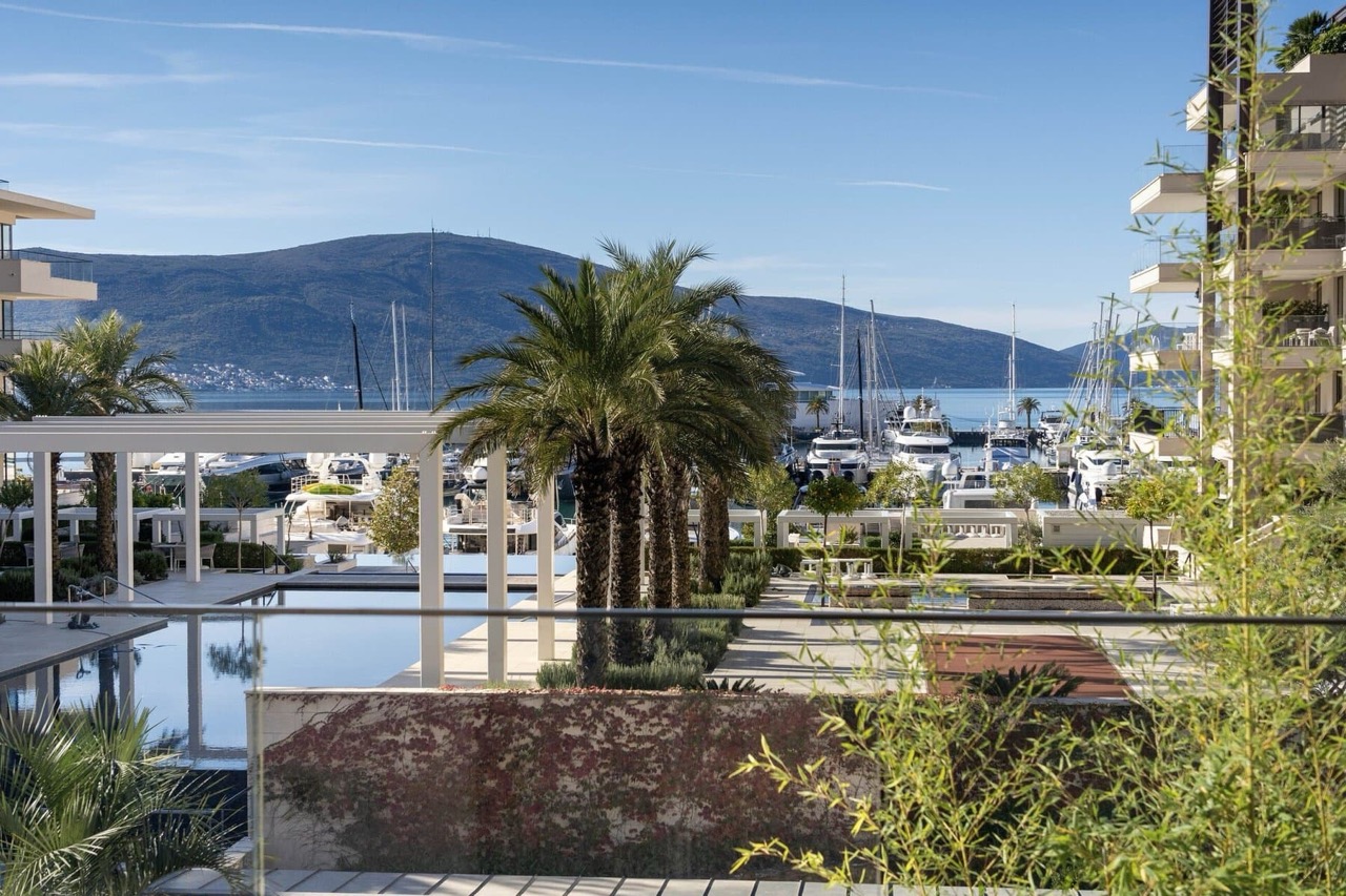 Pogled sa terase na marinu Porto Montenegro, bazen i jahte u Tivtu, Crna Gora. Luksuzna nekretnina uz more.