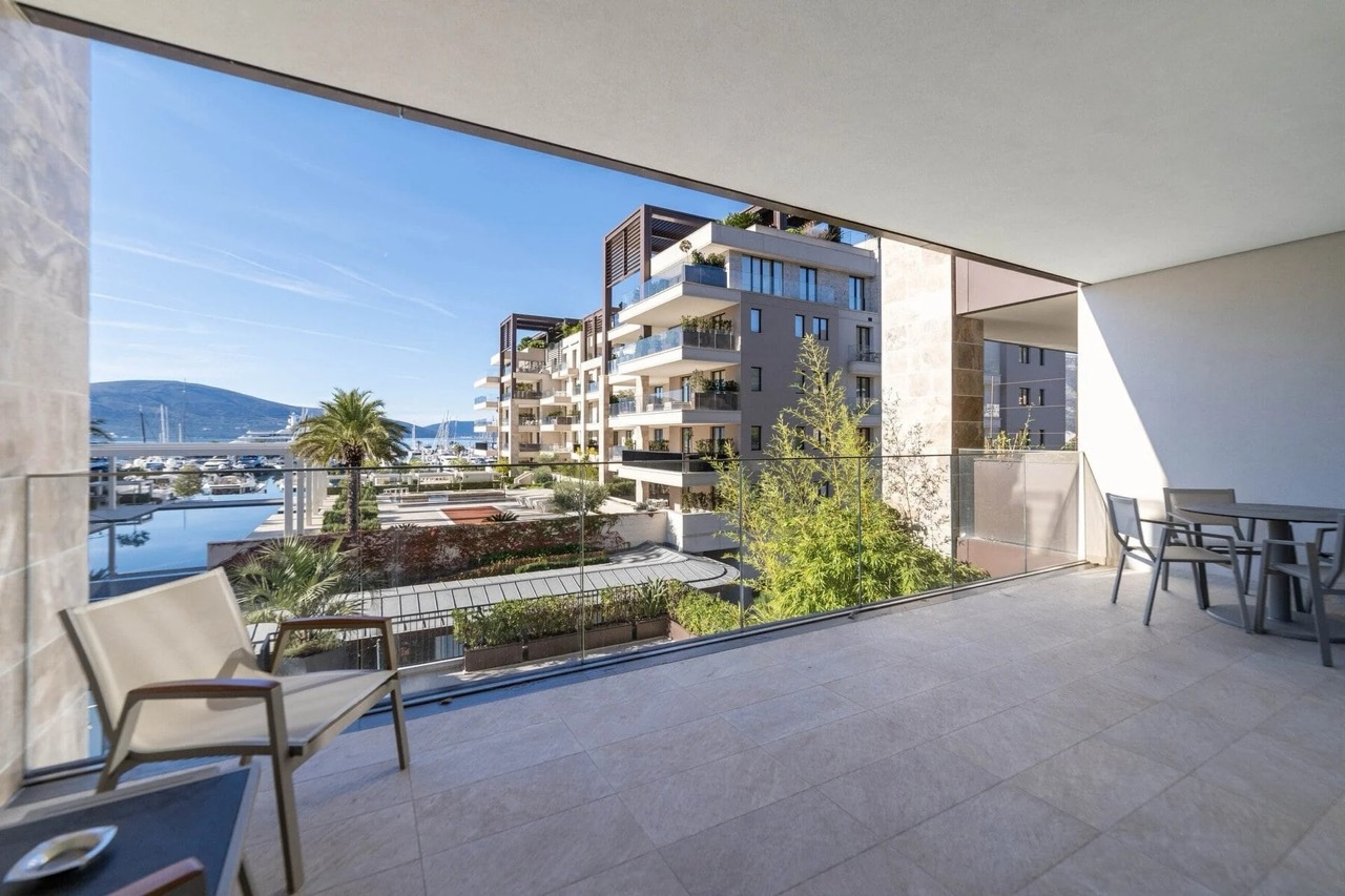 Prostran balkon sa nameštajem i pogledom na marinu i jahte u elitnom kompleksu Porto Montenegro, Tivat, Crna Gora.