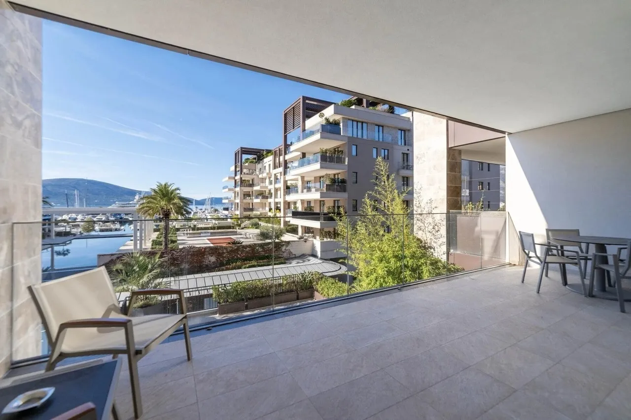 Spacious balcony with furniture and views of the marina and yachts in the prestigious Porto Montenegro complex, Tivat, Montenegro.