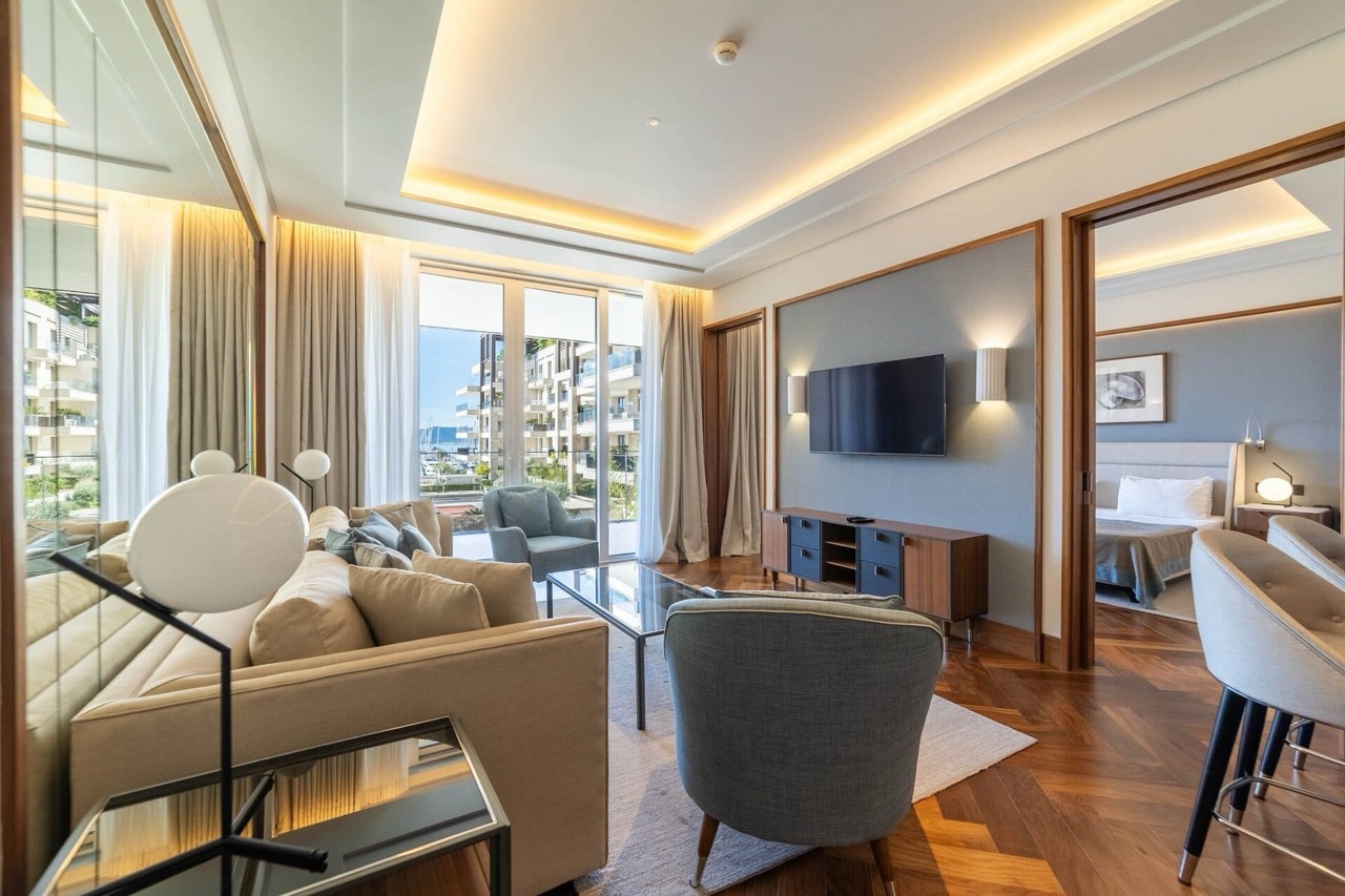 Savremena dnevna soba u apartmanima Porto Montenegro, Tivat, Crna Gora: stilni nameštaj, parket i pogled na marinu.