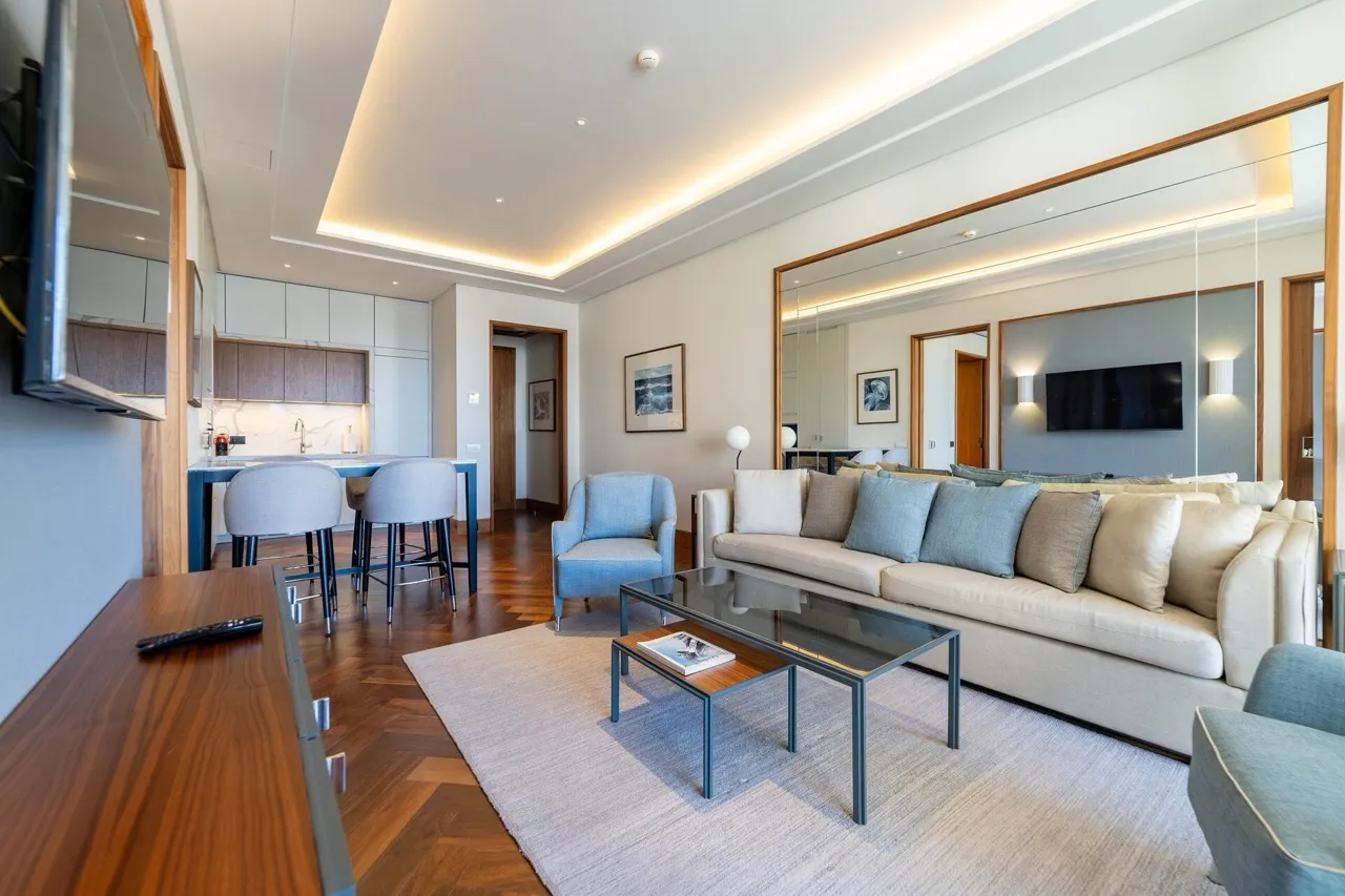 Modern living room with kitchen in an apartment in Porto Montenegro, Tivat, Montenegro: stylish furniture, parquet flooring, and decor.
