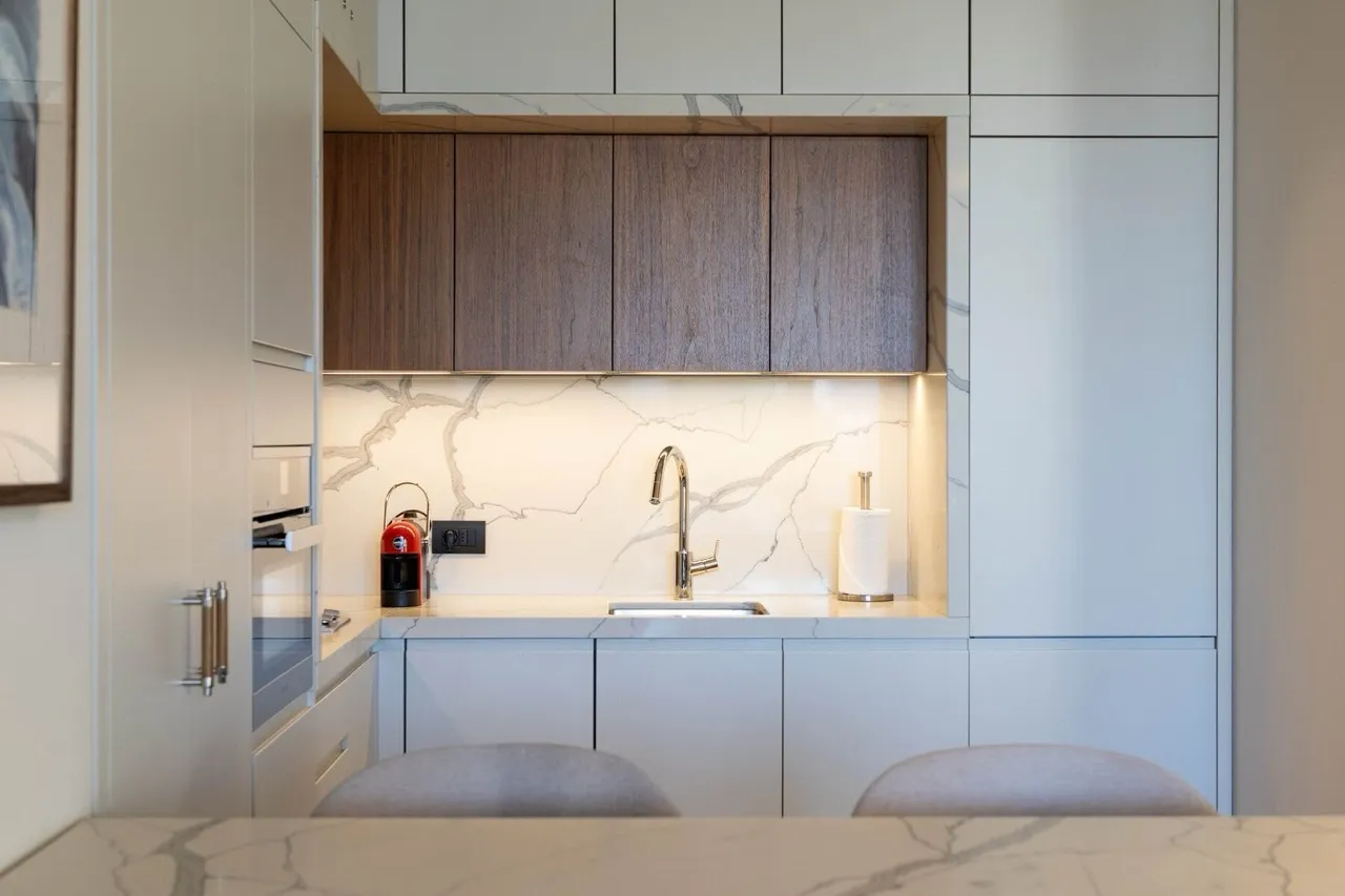 Modern kitchen with a marble backsplash and wooden cabinets in an apartment in Porto Montenegro, Tivat, Montenegro.