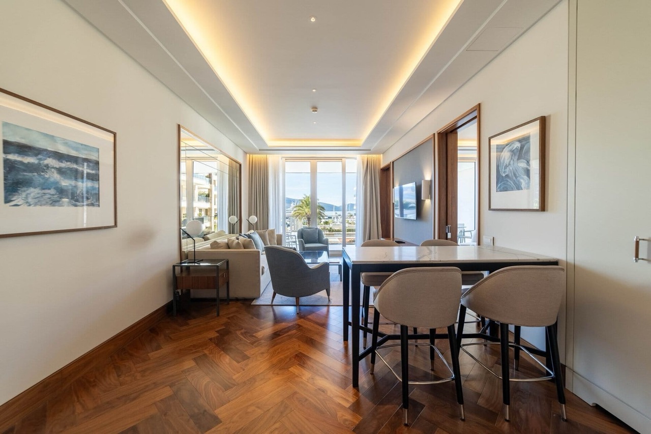 Savremena dnevna soba u stanu Porto Montenegro, Tivat, Crna Gora: parket, stilski nameštaj i pogled na marinu.
