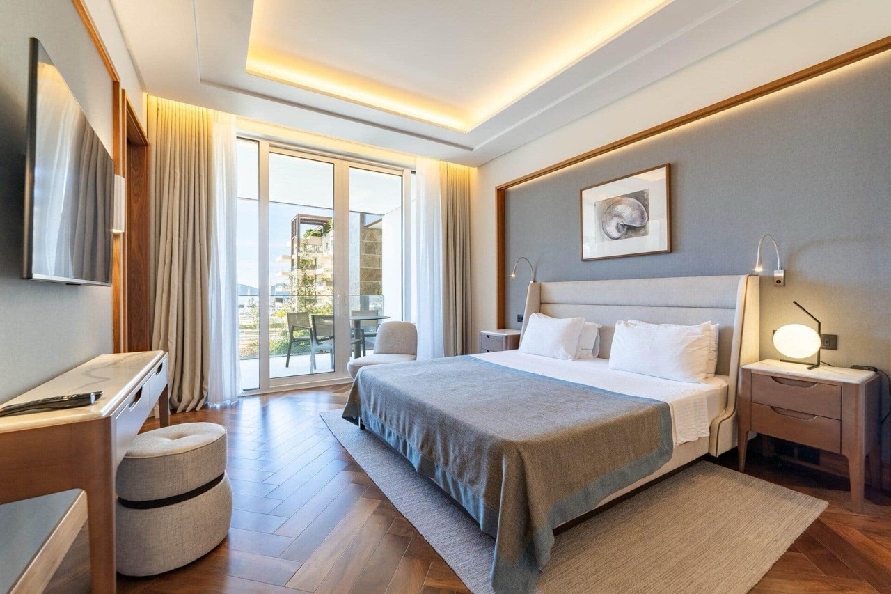 Savremena spavaća soba u stanu Porto Montenegro, Tivat, Crna Gora: bračni krevet, terasa i pogled na more.