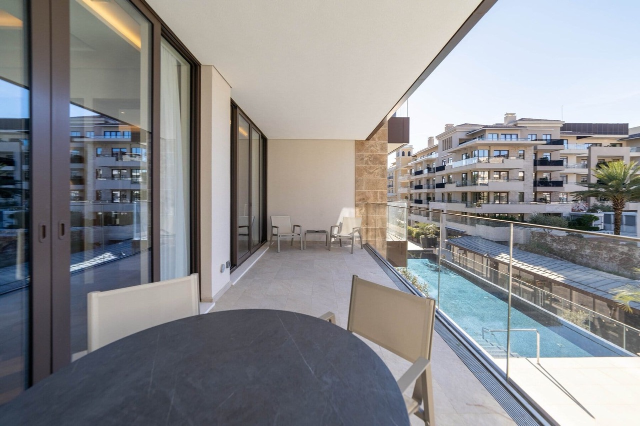 Prostran balkon sa nameštajem i pogledom na bazen u elitnom stambenom kompleksu Porto Montenegro, Tivat, Crna Gora.