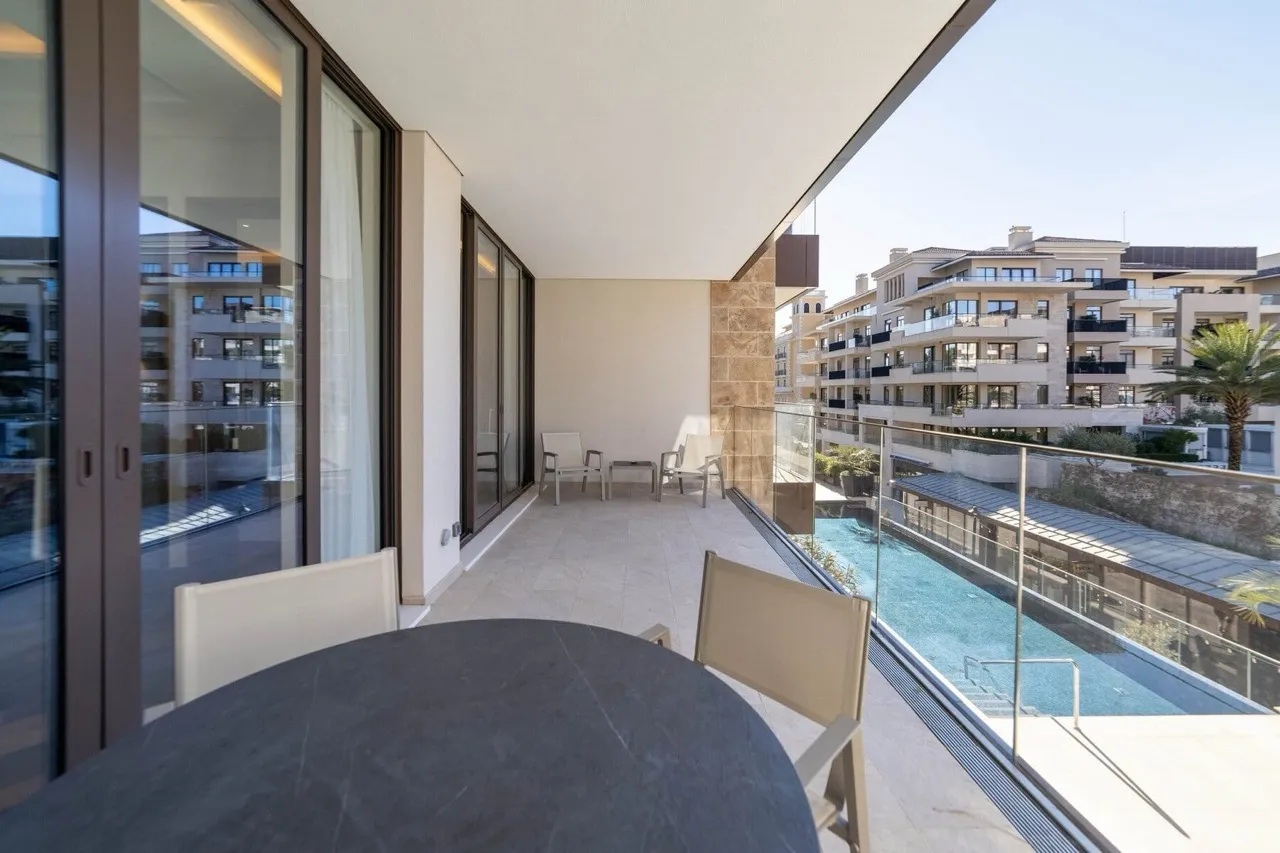 Spacious balcony with furniture and a view of the pool in the luxury Porto Montenegro residential complex, Tivat, Montenegro.