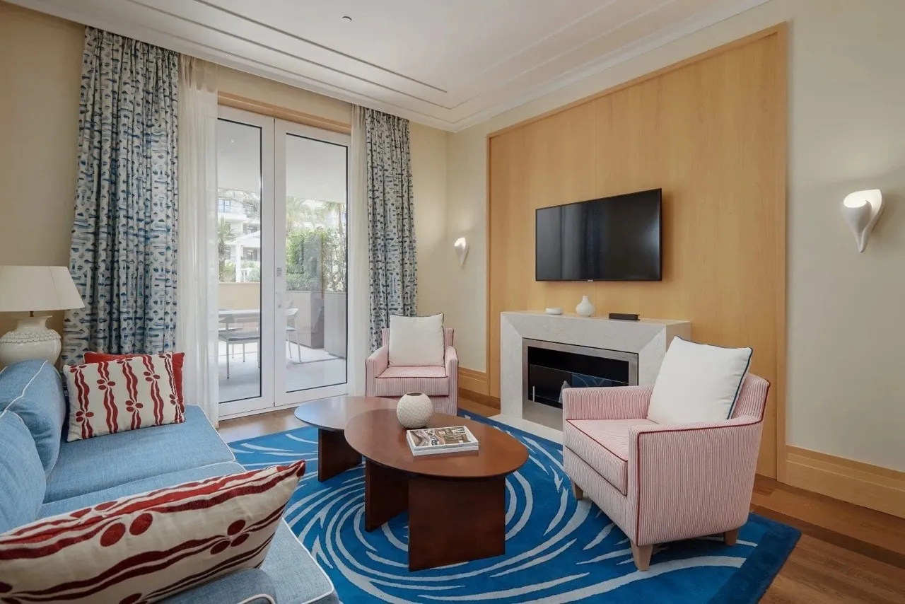 Wohnzimmer mit Kamin und Terrasse in den Apartments von Porto Montenegro, Tivat, Montenegro: modernes Interieur mit Möbeln.