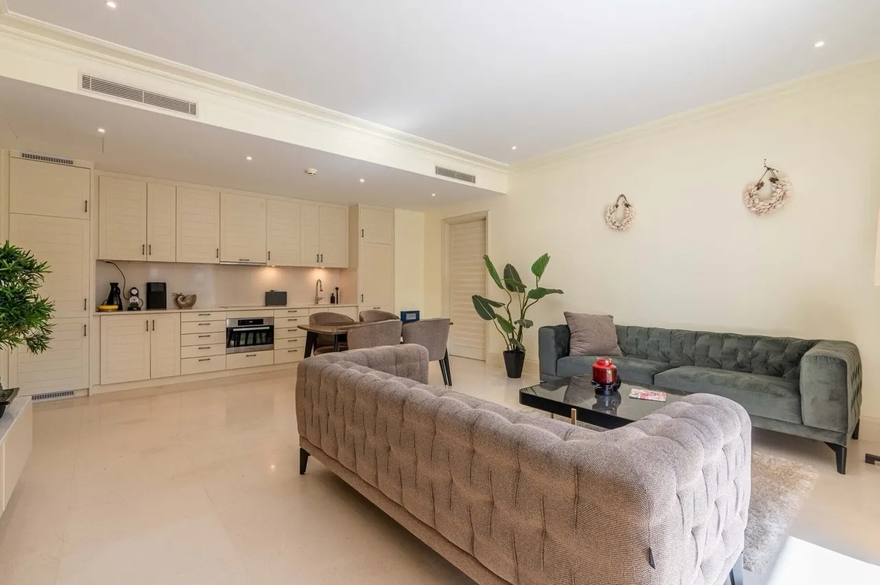 Modernes Wohnzimmer mit Küche in einer Wohnung in Porto Montenegro, Tivat, Montenegro: weiche Sofas und helles Interieur.
