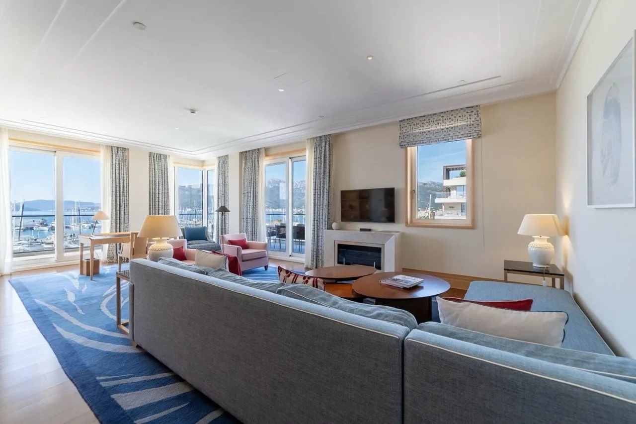 Geräumiges Wohnzimmer mit Plüschsofa, Panoramafenstern mit Meerblick und Kamin.