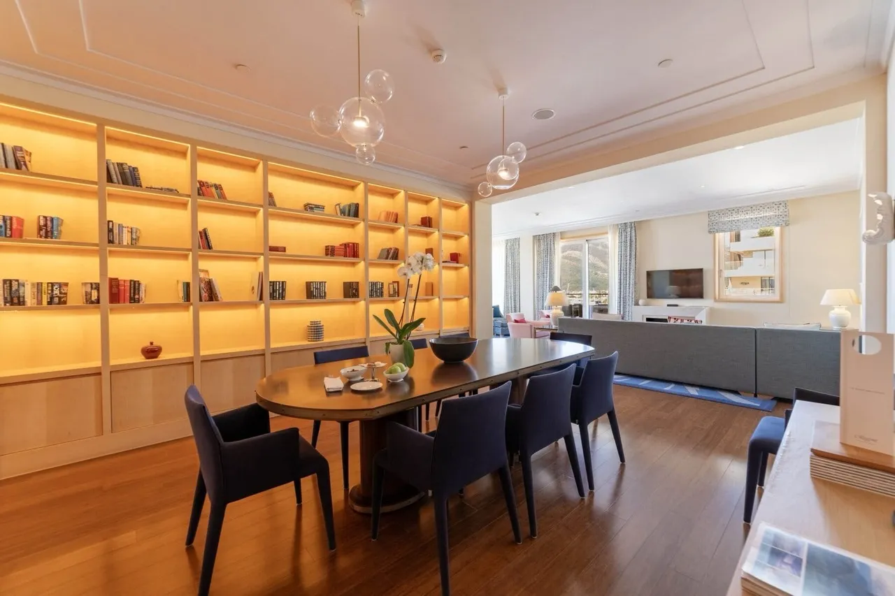 Geräumiges Wohnzimmer mit Einbaubücherregalen, Esstisch und Loungebereich mit Sofa.