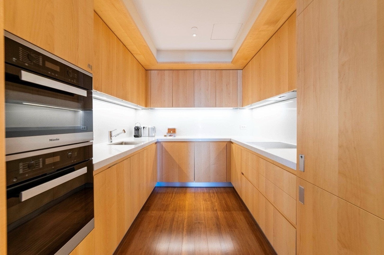 Современная кухня с деревянными фасадами и техникой Miele в апартаментах Порто Монтенегро, Тиват, Черногория.