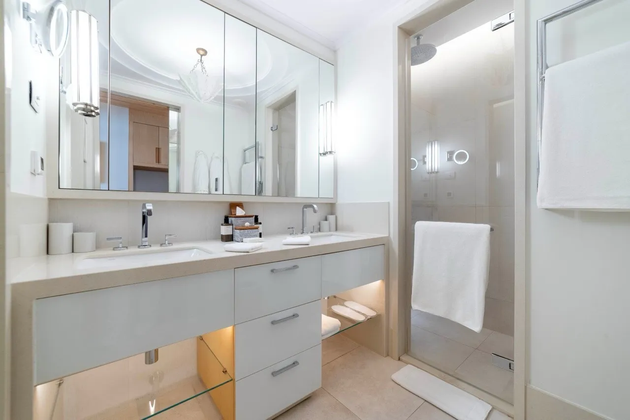 Modernes Badezimmer mit Doppelwaschbecken, großem Spiegel und Dusche.