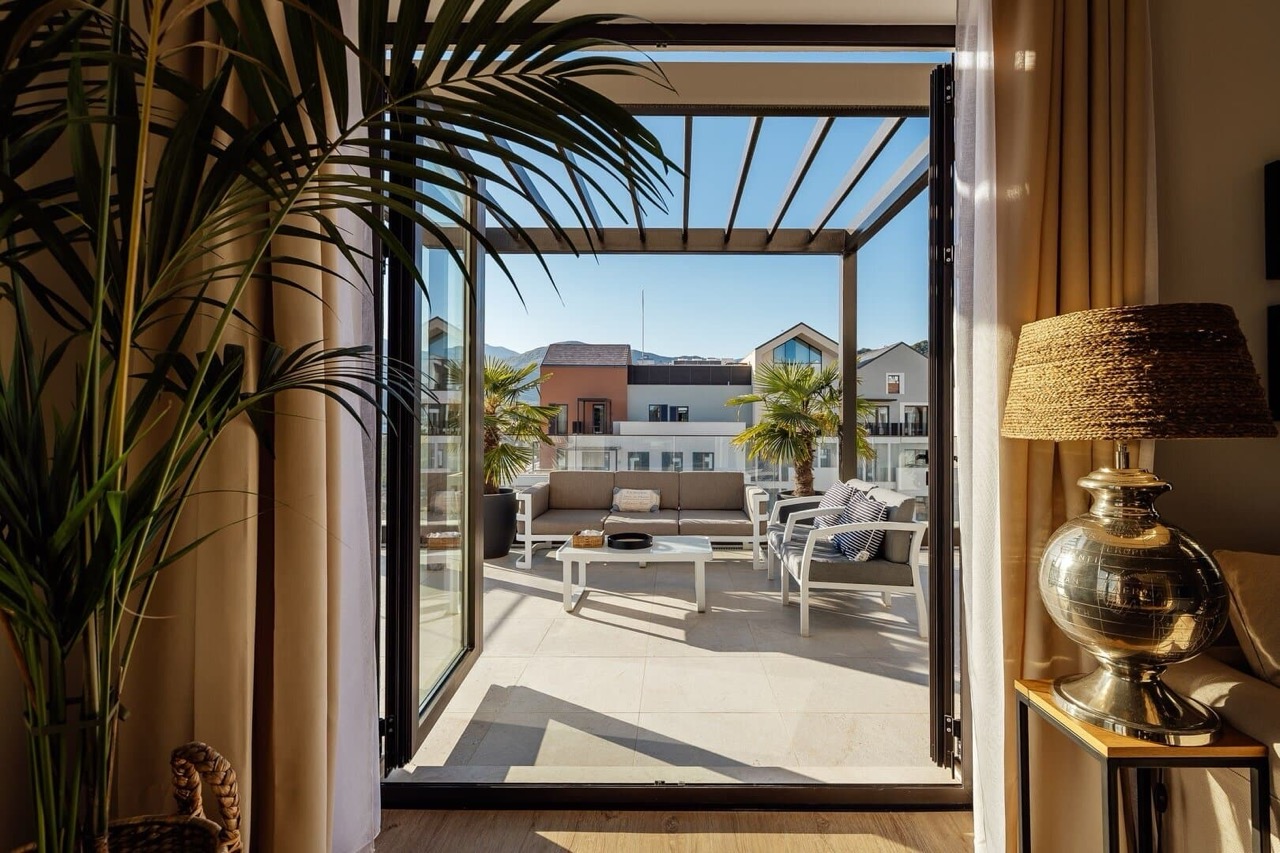 Терраса с мебелью и перголой в квартире Porto Montenegro, Тиват, Черногория: вид на город и горы из апартаментов.