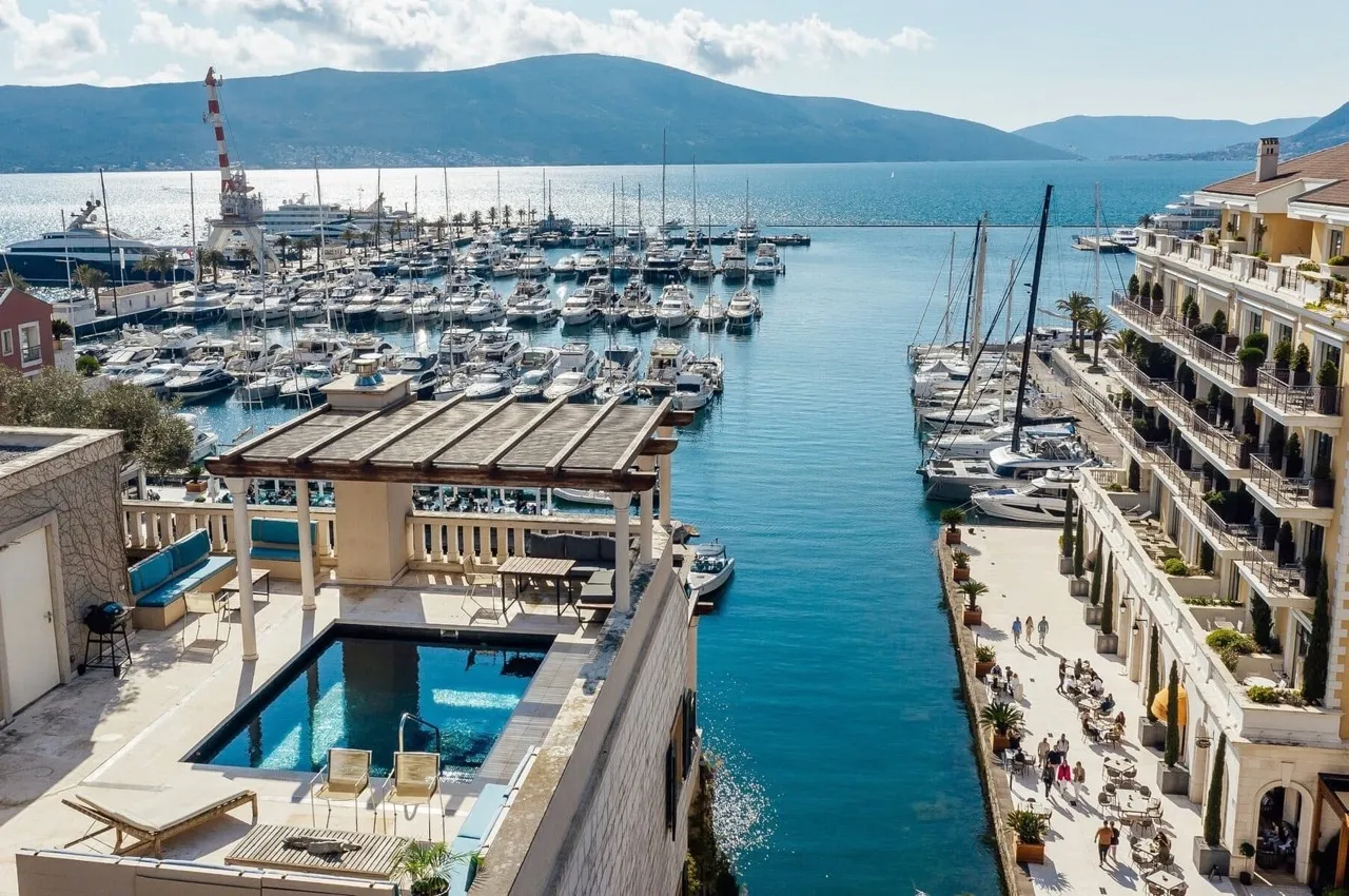 Vue sur la piscine sur la terrasse et la marina de yachts Porto Montenegro, Tivat, Monténégro : bien immobilier de luxe en bord de mer.